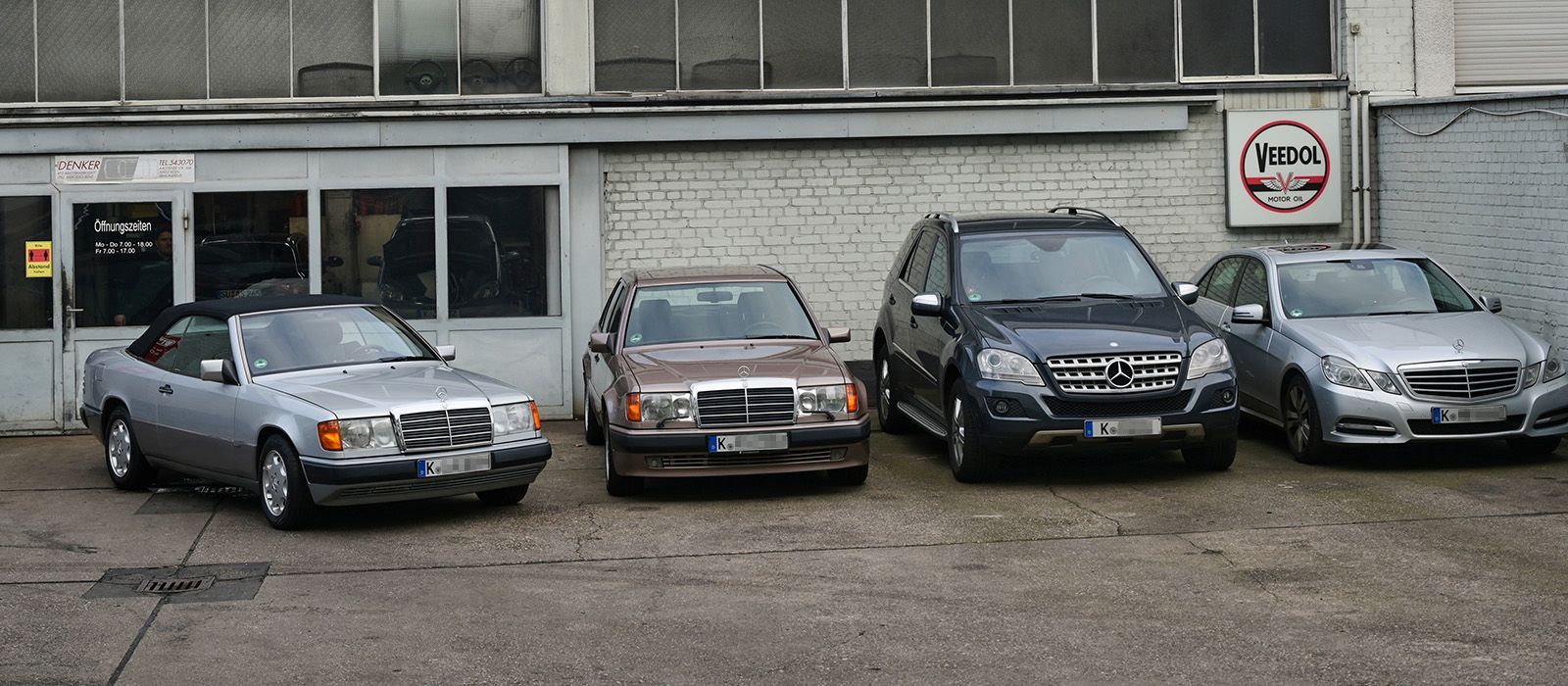 Vor einem Gebäude parken mehrere Autos.