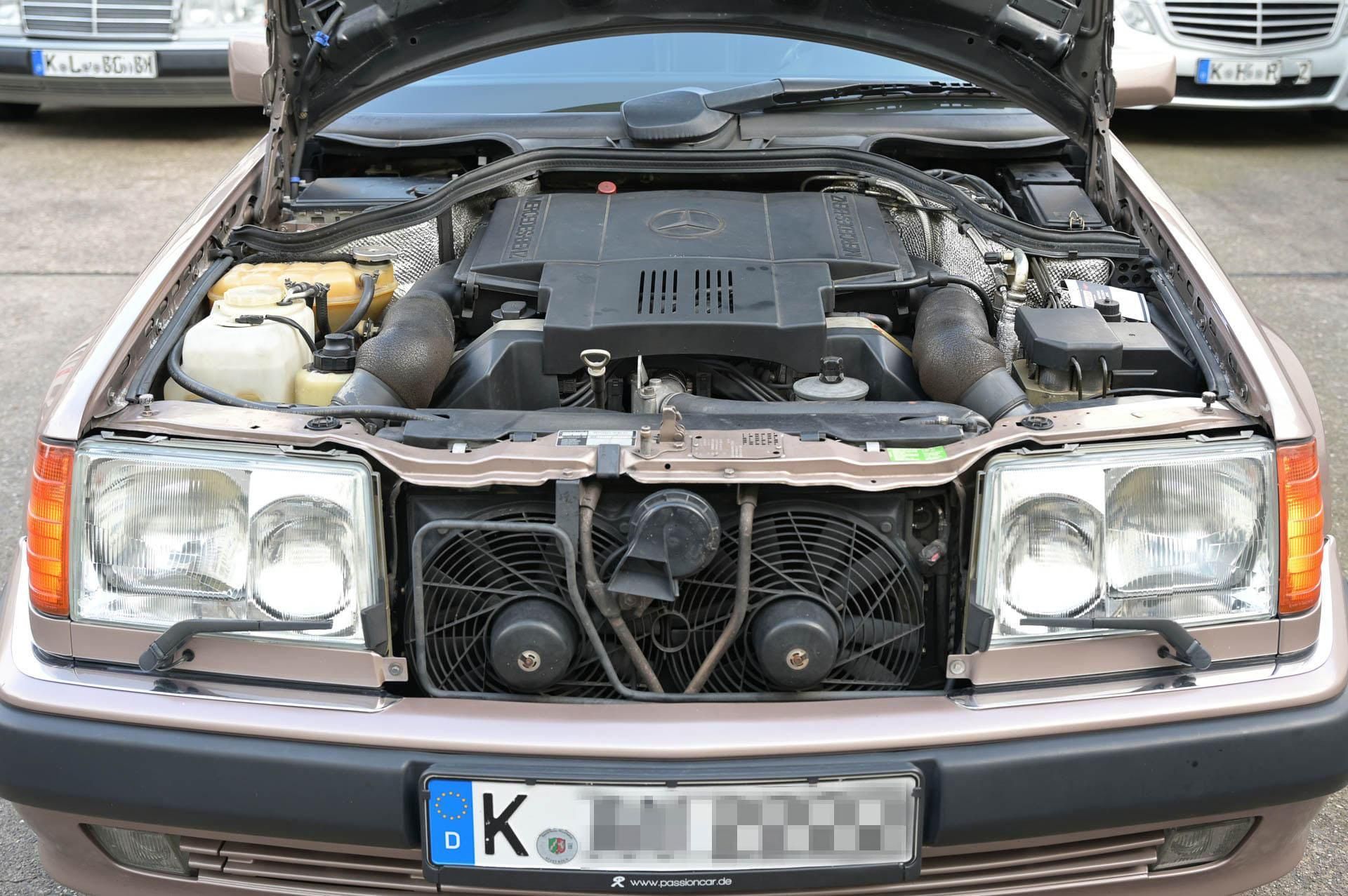 Ein Auto mit geöffneter Motorhaube hat ein Nummernschild mit der Aufschrift „K“