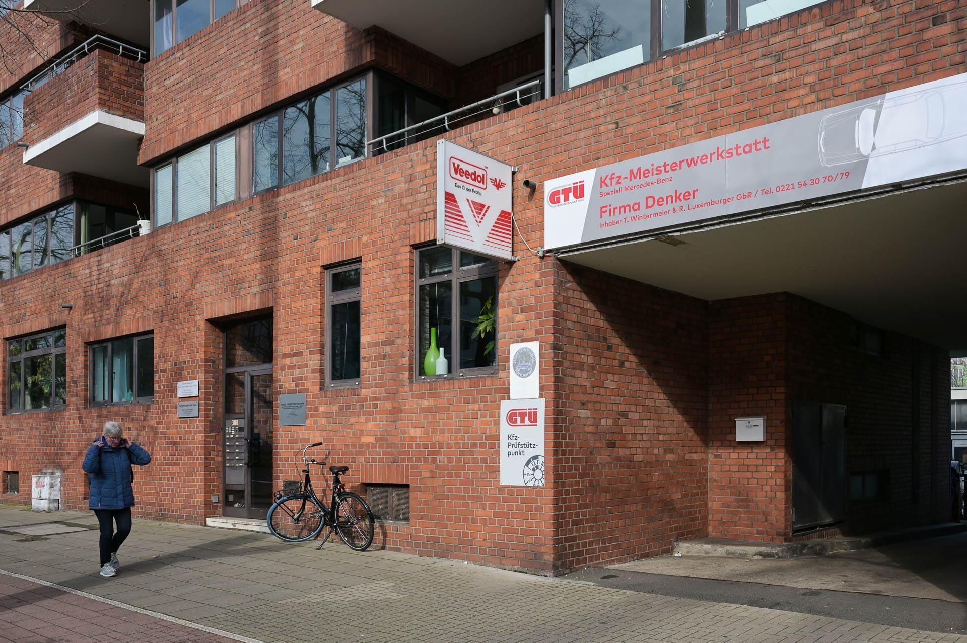 Ein Mann geht vor einem großen Backsteingebäude.