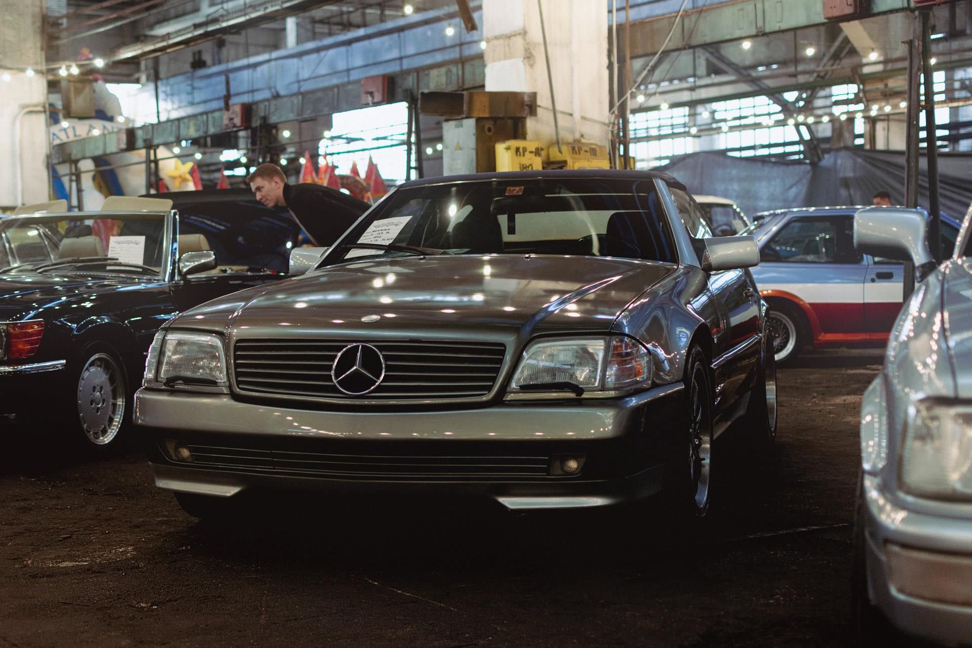 Ein Mercedes steht mit anderen Autos in einem Ausstellungsraum