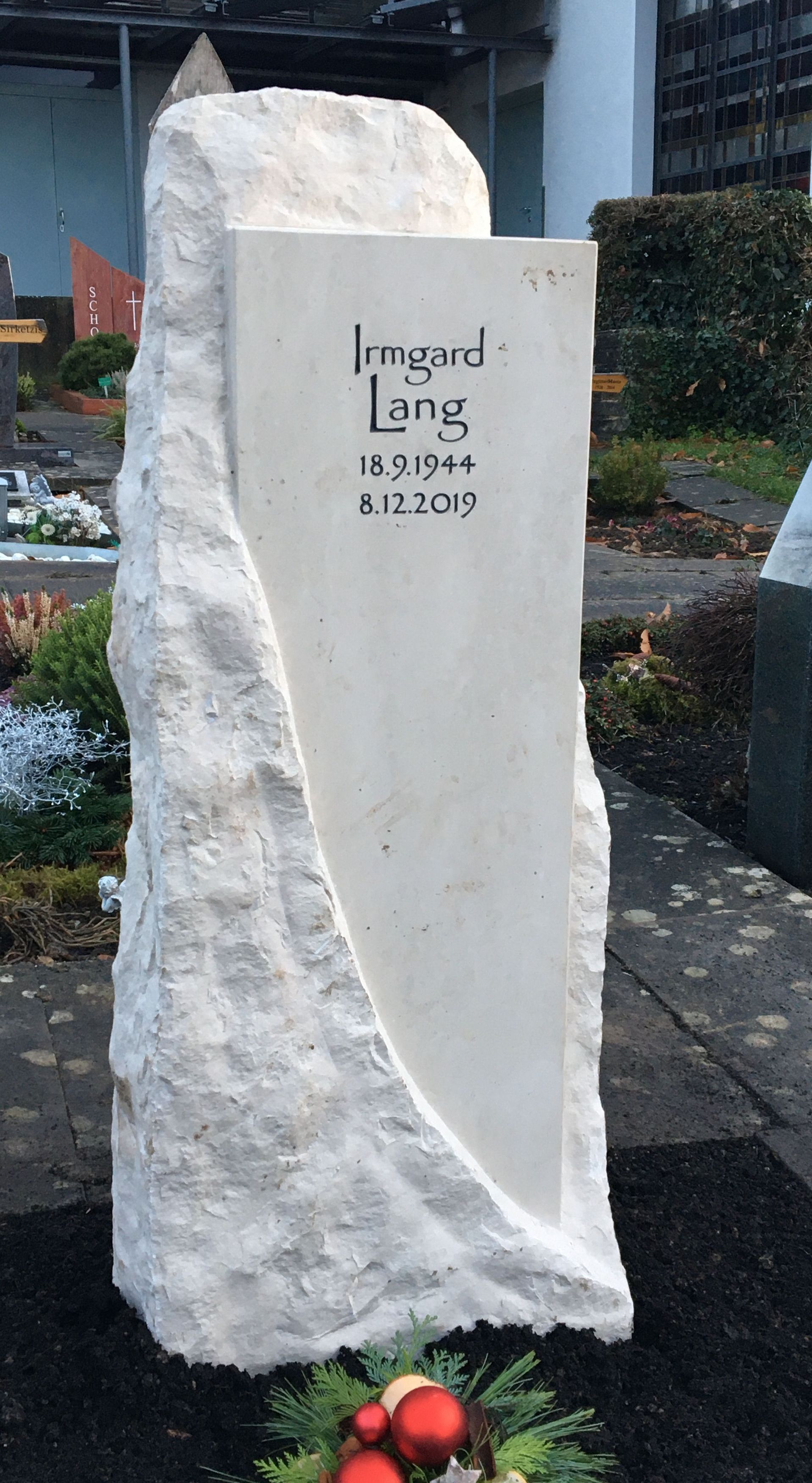 Ein großes weißes Steindenkmal mit einem Weihnachtskranz davor.