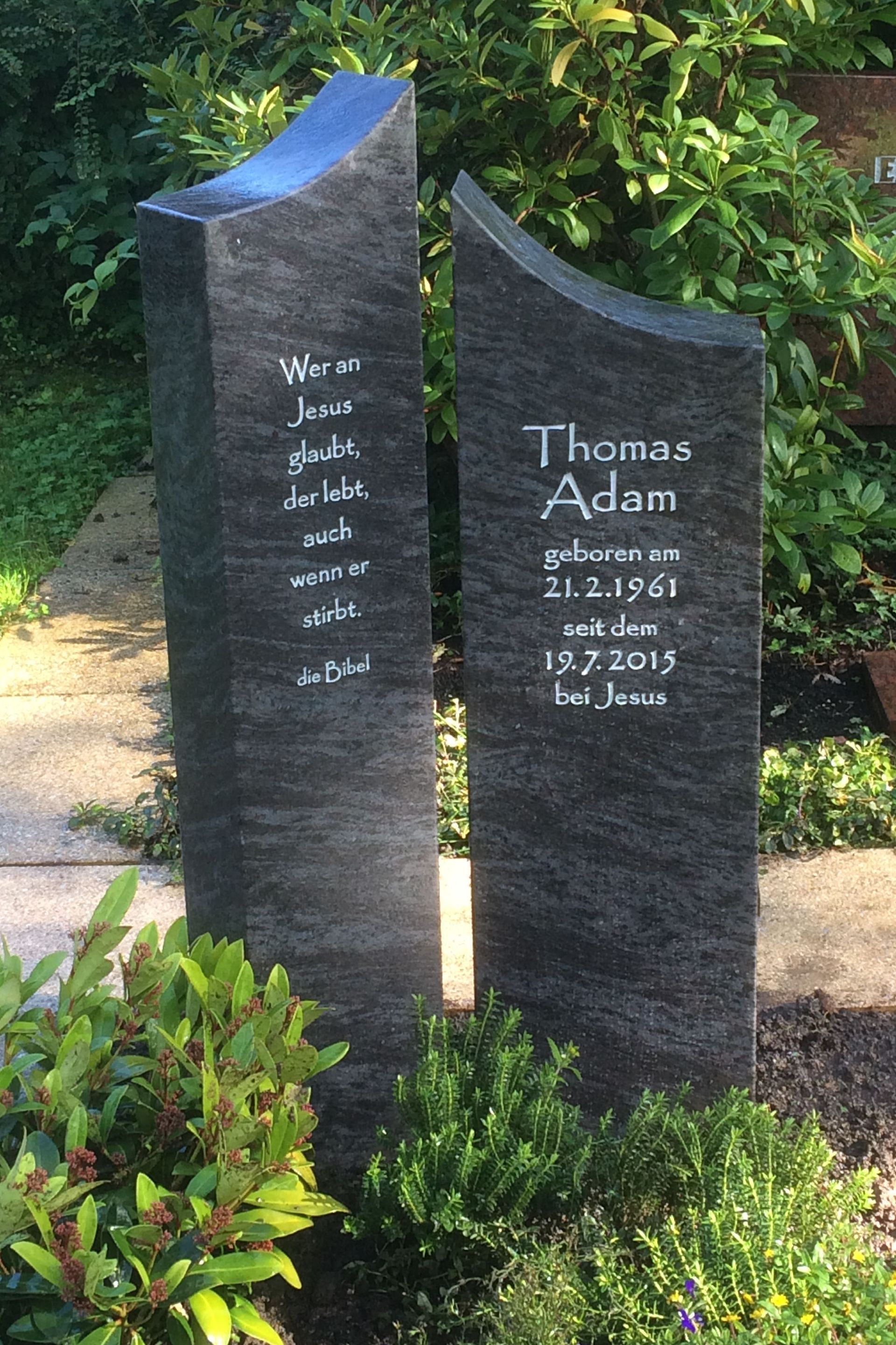 In einem Garten stehen einige Grabsteine ​​nebeneinander.