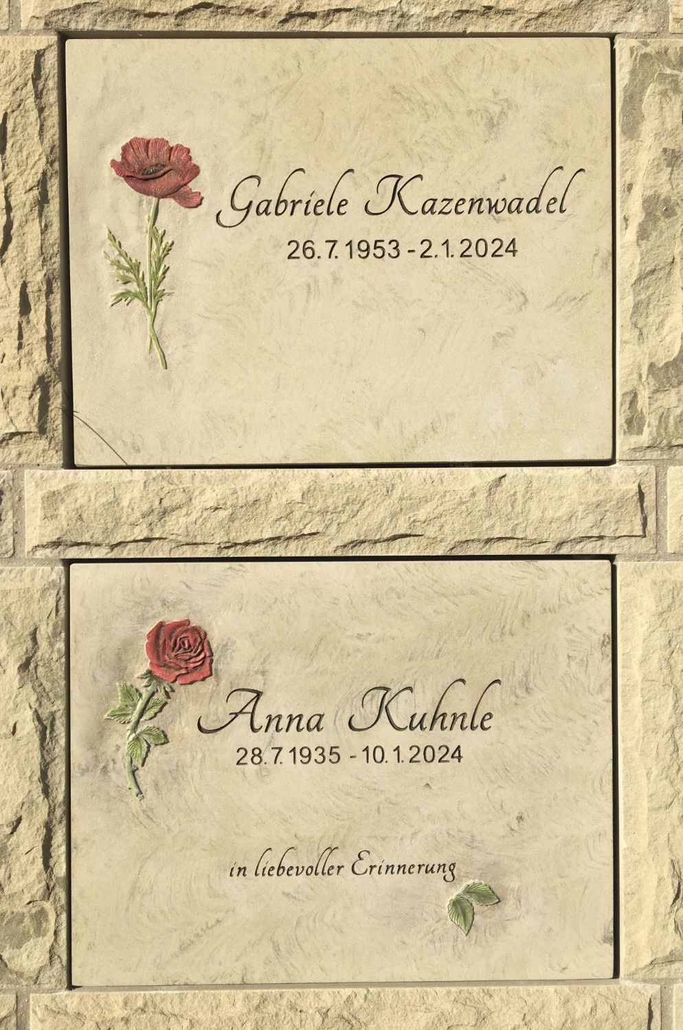 Ein paar Grabsteine mit einer roten Rose darauf.