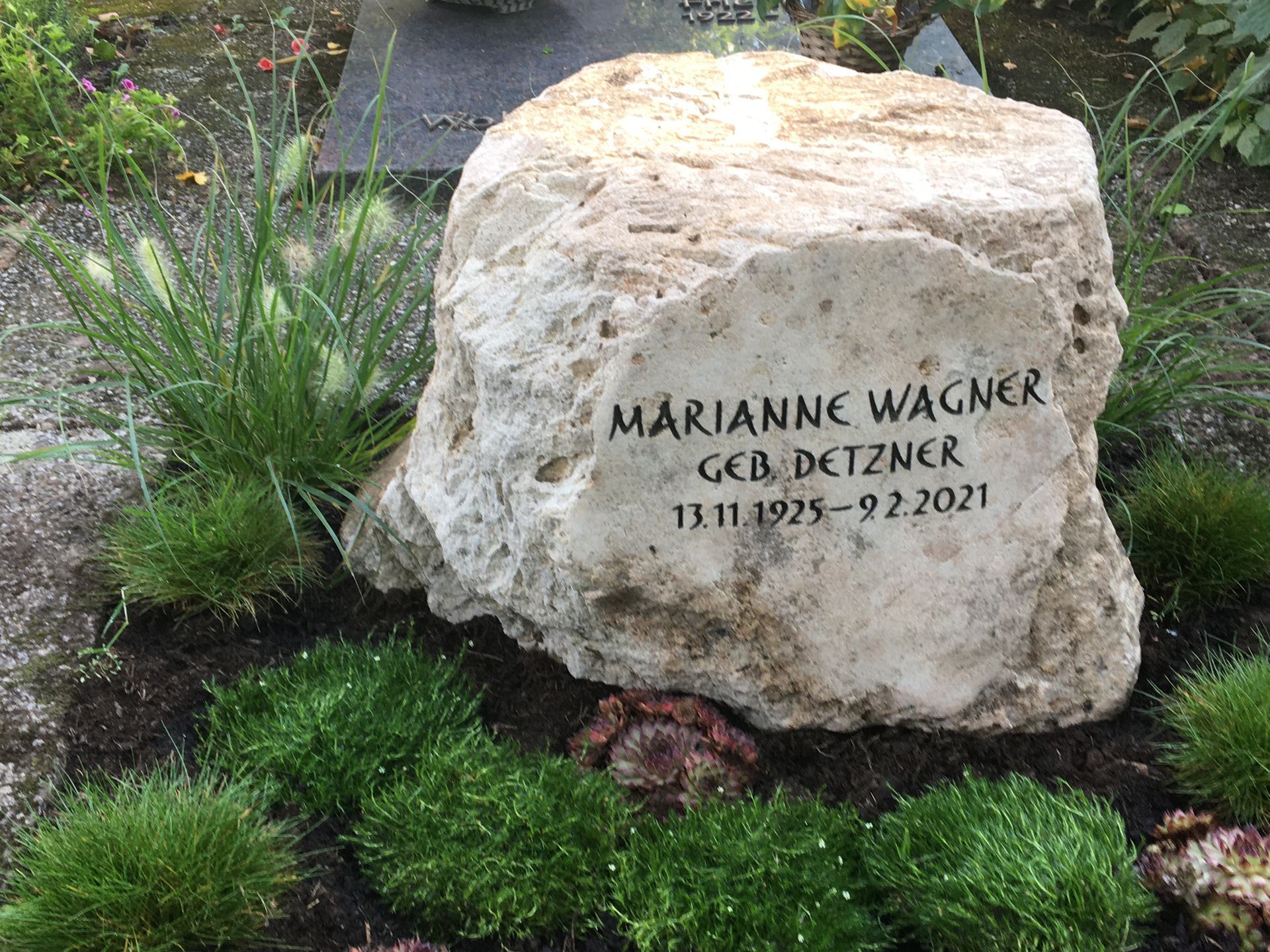 Auf einem Friedhof liegt ein großer Stein mit dem Namen Marianne Wagner.