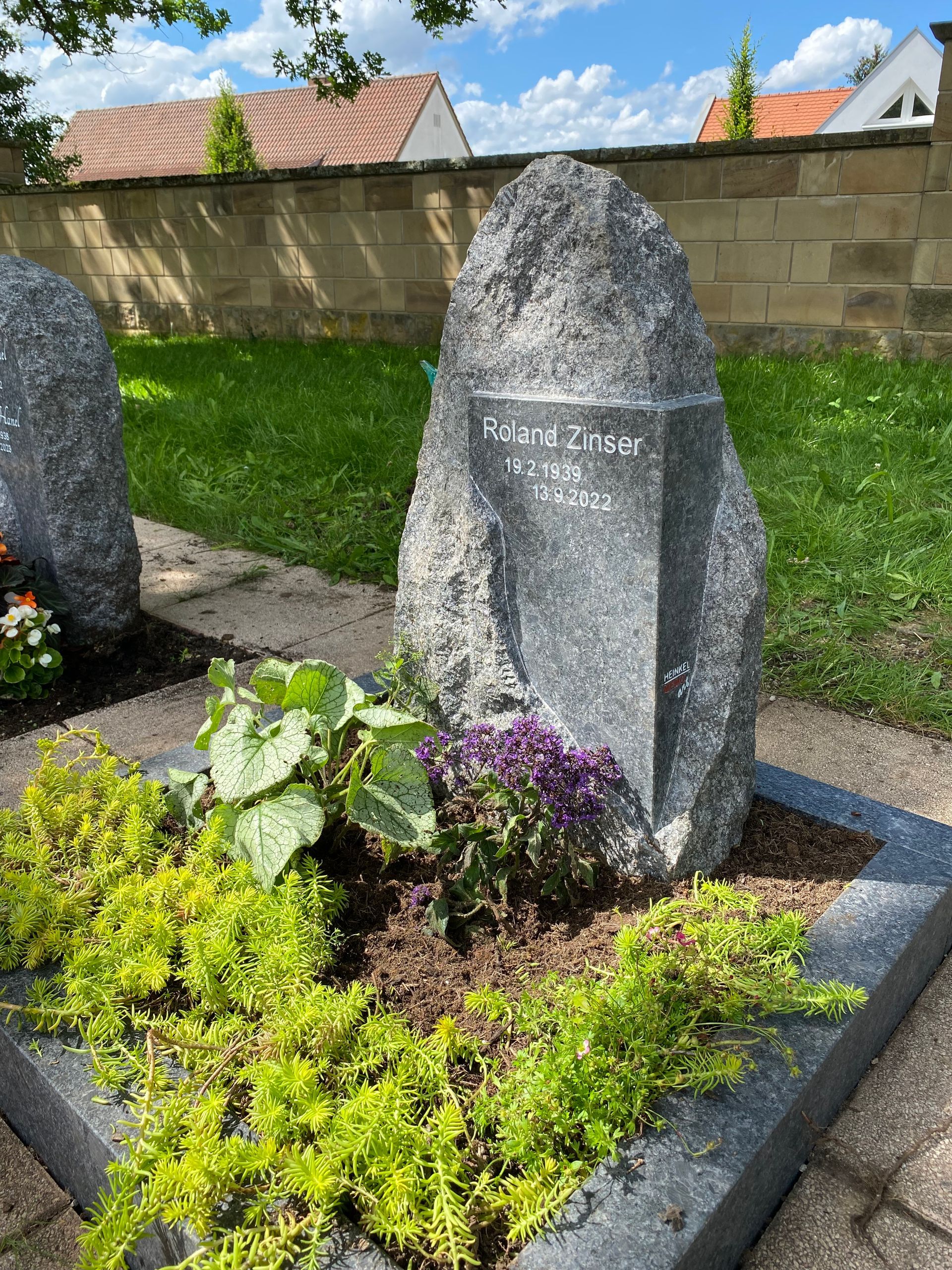 Ein Grab mit einem großen Felsen inmitten eines Gartens.