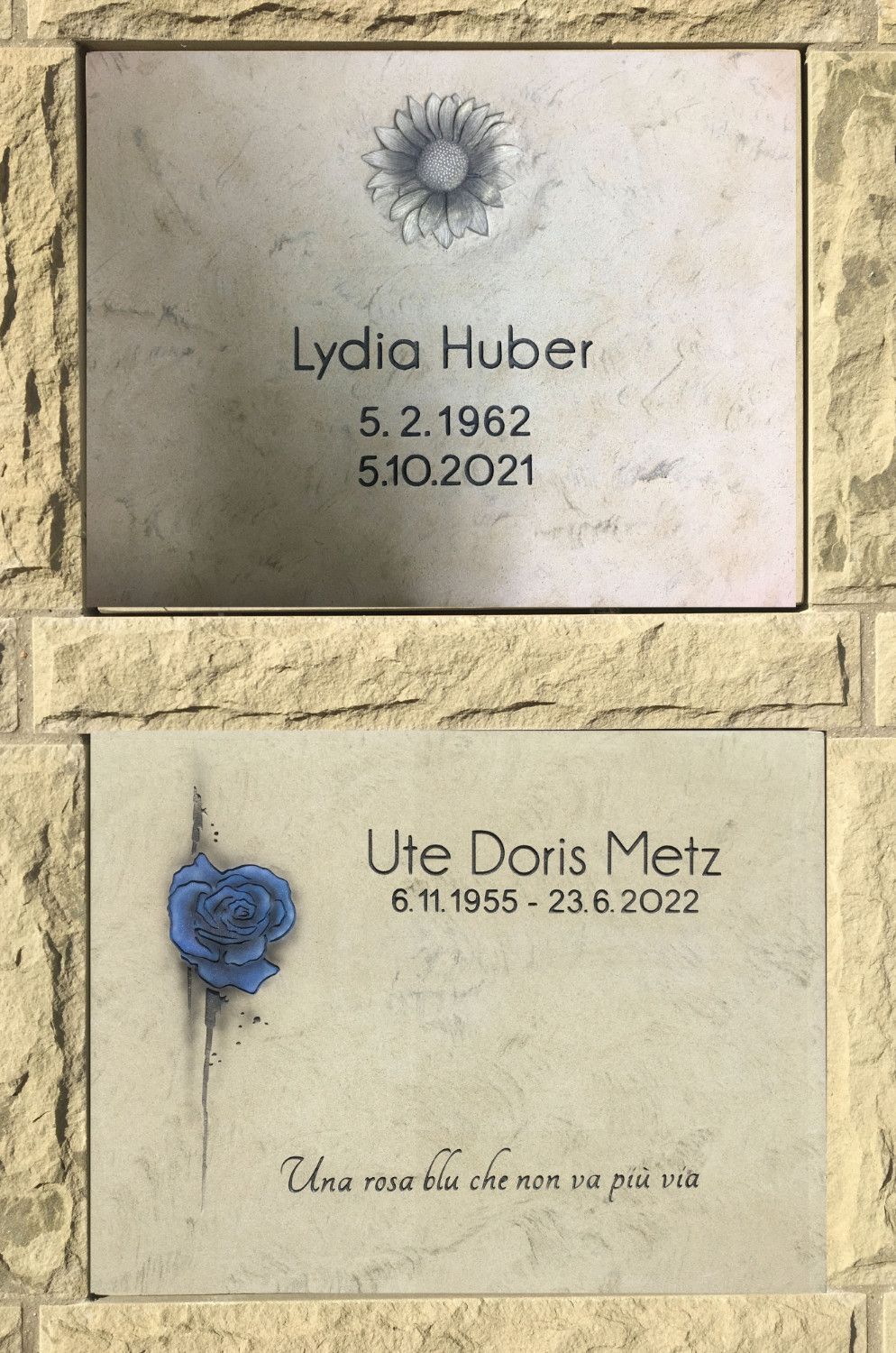 An einer Wand hängen ein paar Plaketten mit der Aufschrift „Lydia Huber“ und „Ute Doris Metz“.