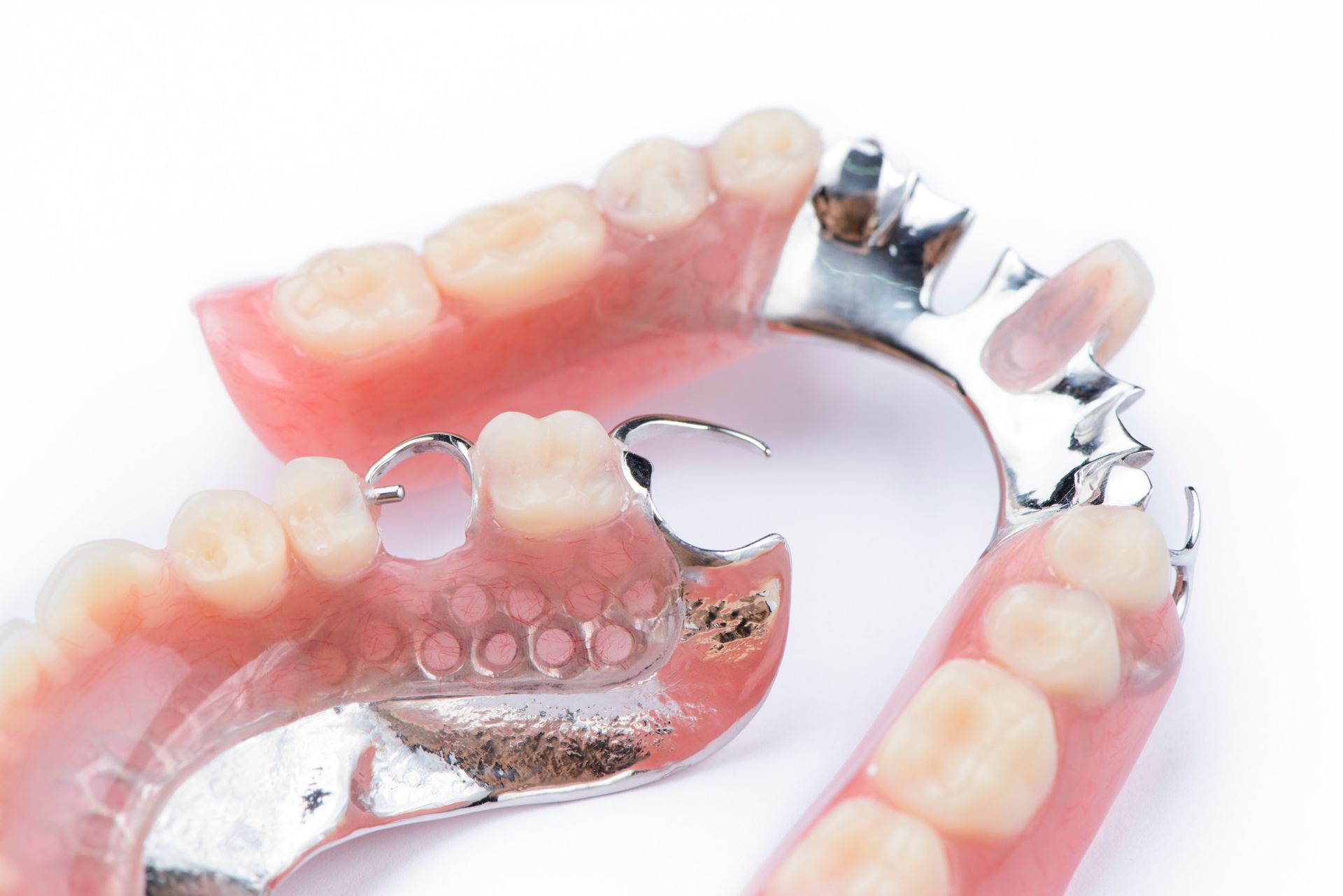 Un primer plano de un par de dentaduras postizas sobre una superficie blanca.