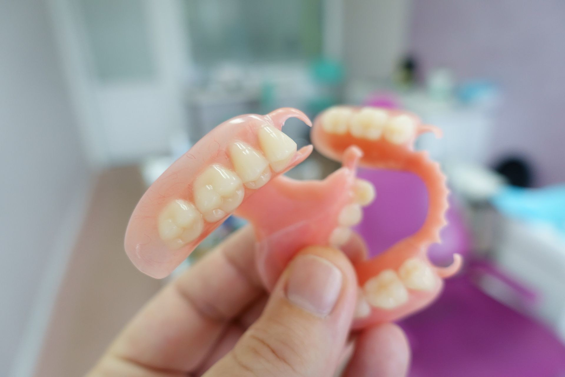 Una persona sostiene una dentadura postiza en su mano.