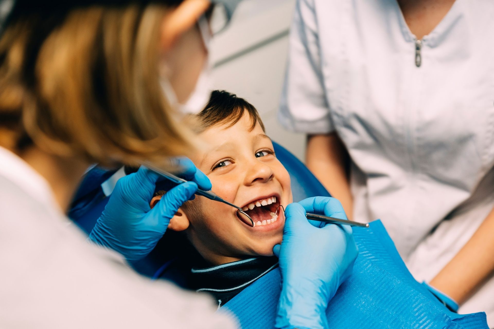 A un niño pequeño le están examinando los dientes un dentista.