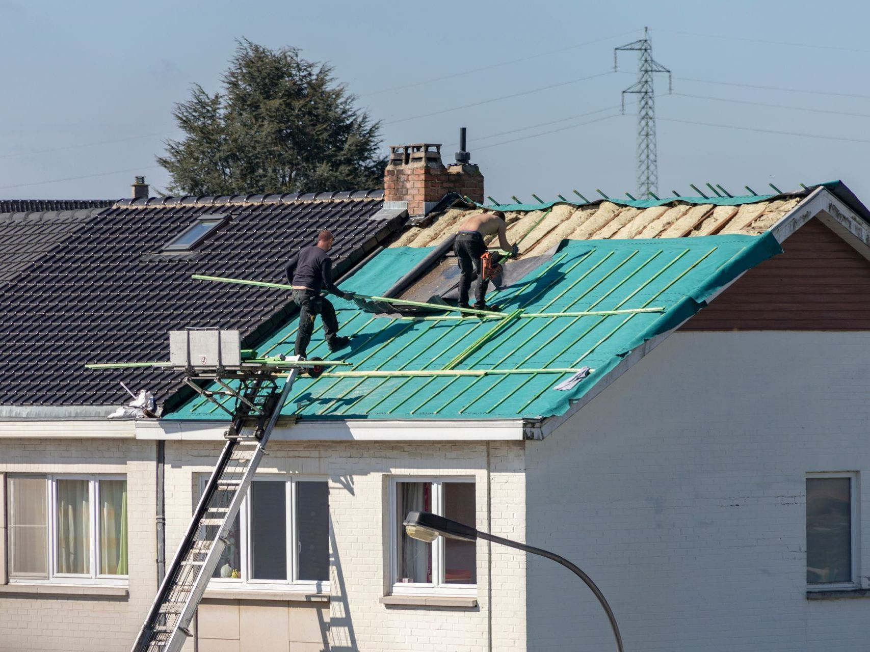 Deux artisans en train d'isoler une toiture