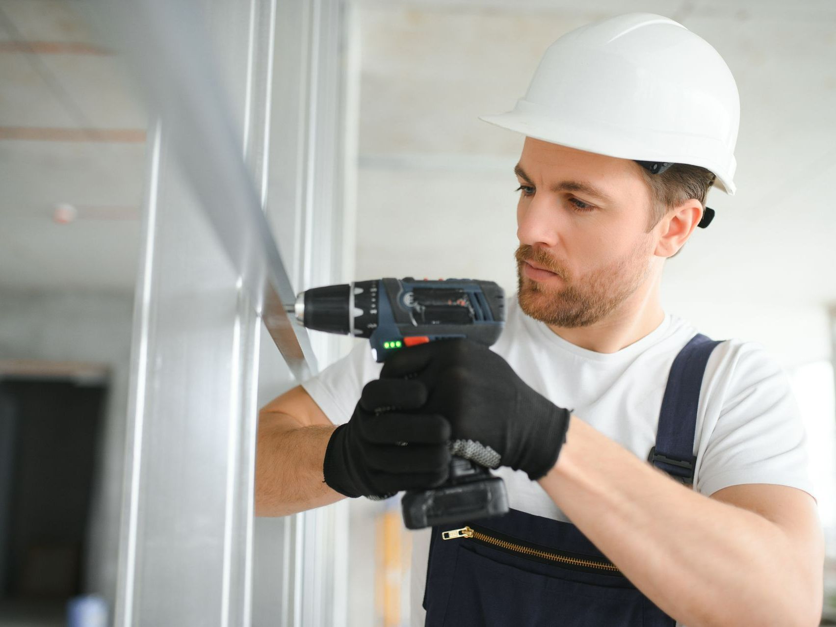 Ouvrier qui utilise une perceuse pour fixer la rambarde métallique