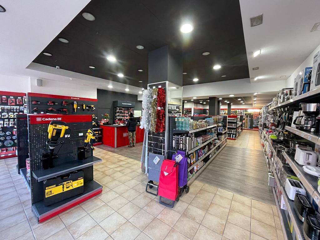Interior de una ferretería con herramientas y electrodomésticos en estanterías y expositores.