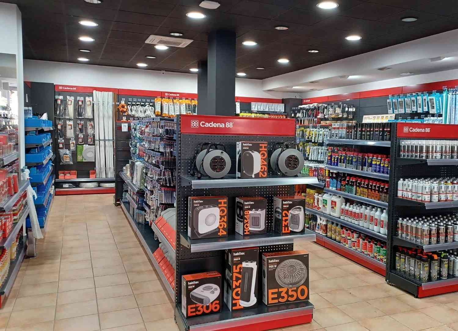 Interior de una tienda de repuestos para automóviles con estantes llenos de productos y un expositor central.