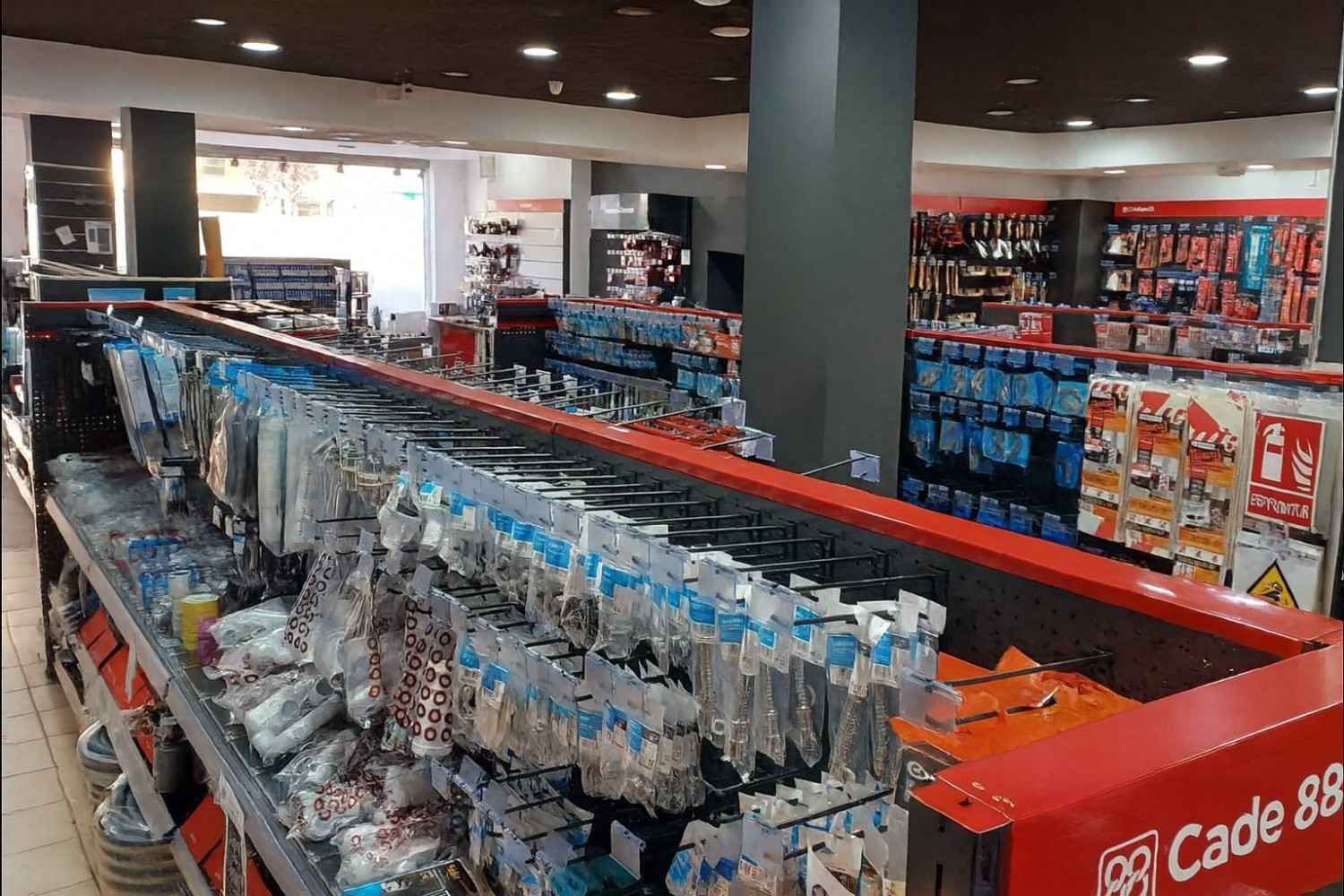 Interior de una ferretería con herramientas y suministros en exhibición.