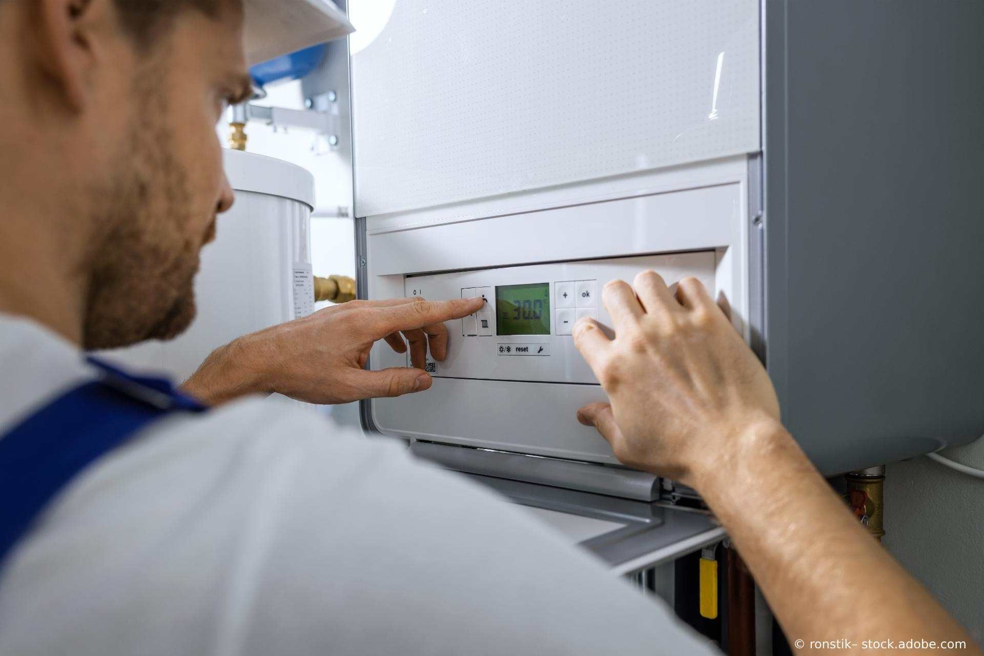 Anlagenmechaniker richtet eine Heizungsanlage ein