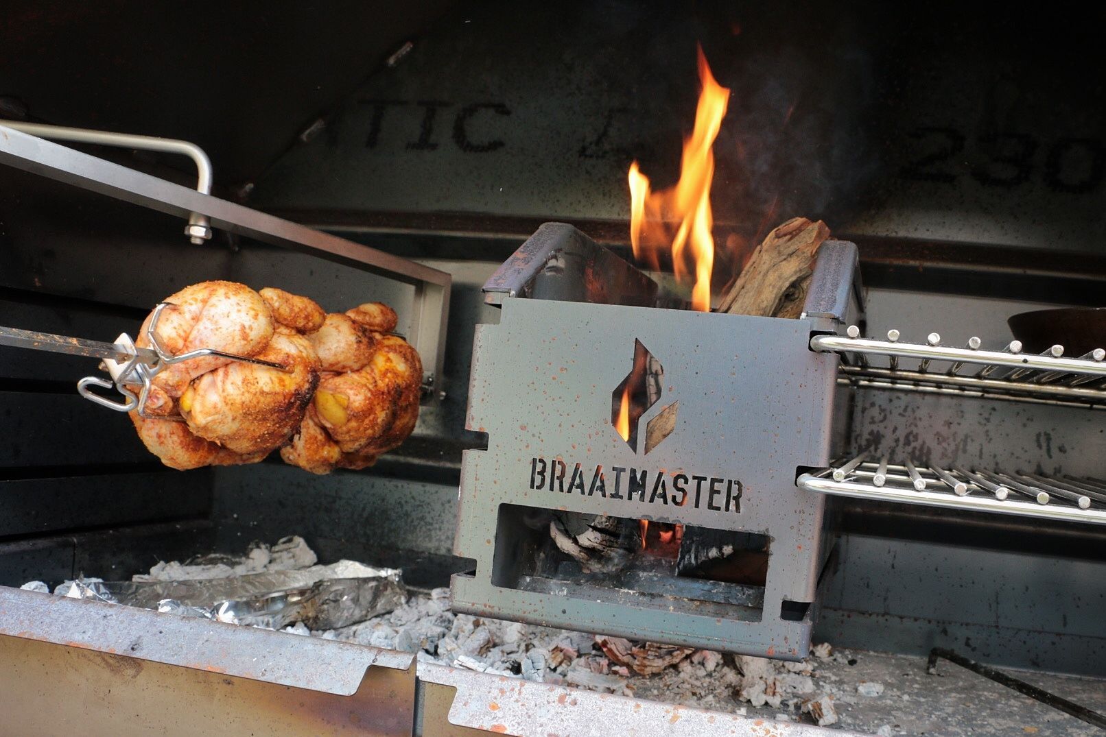 Braaimaster: Un poulet rôti à la broche, cuit au feu de bois dans un barbecue « Braaimaster ».