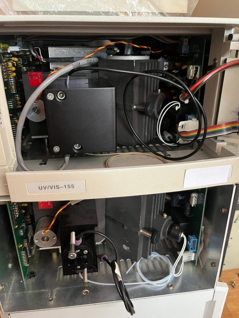 Vista abierta del interior de un instrumento científico con placas de circuito, cables y componentes mecánicos.