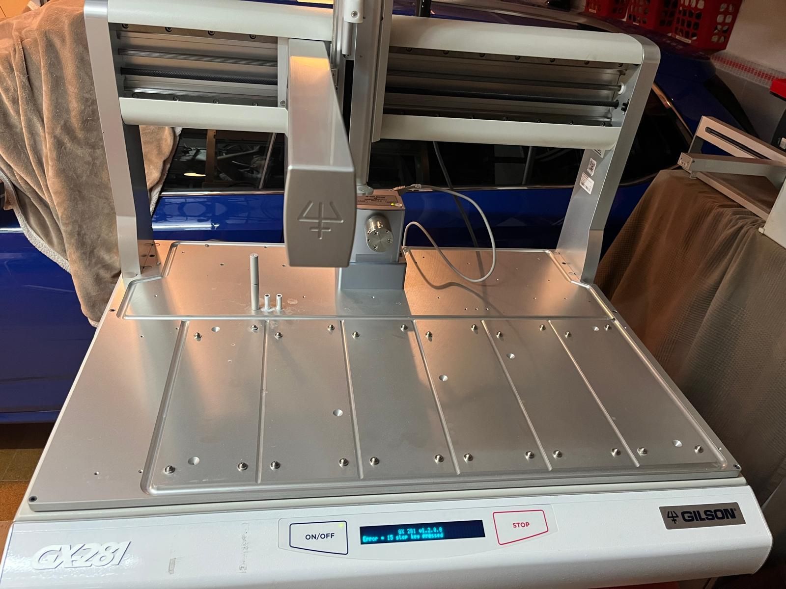 Una cortadora de alimentos GaSon plateada y blanca sobre una mesa. Tiene una pantalla digital y una etiqueta de advertencia.