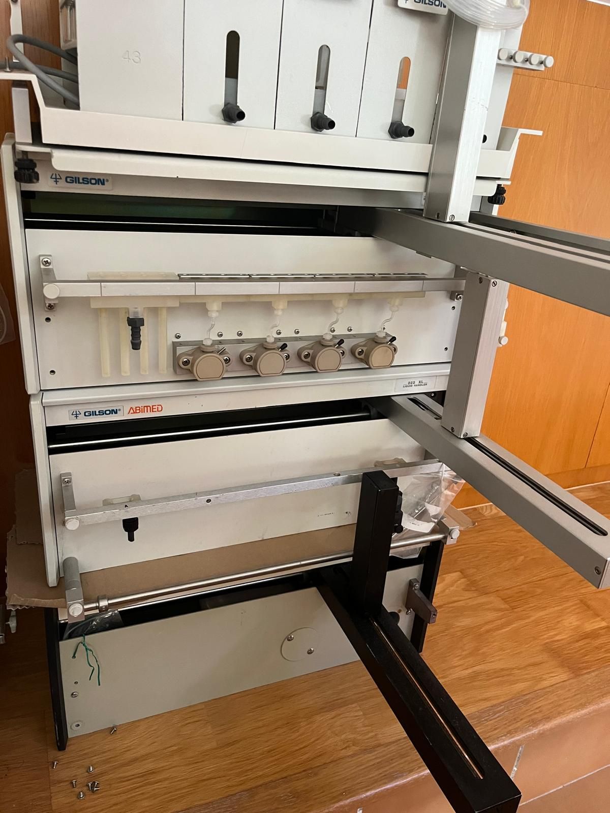 Máquina industrial de color blanco y gris con múltiples rodillos y perillas, posiblemente para imprimir o procesar papel.