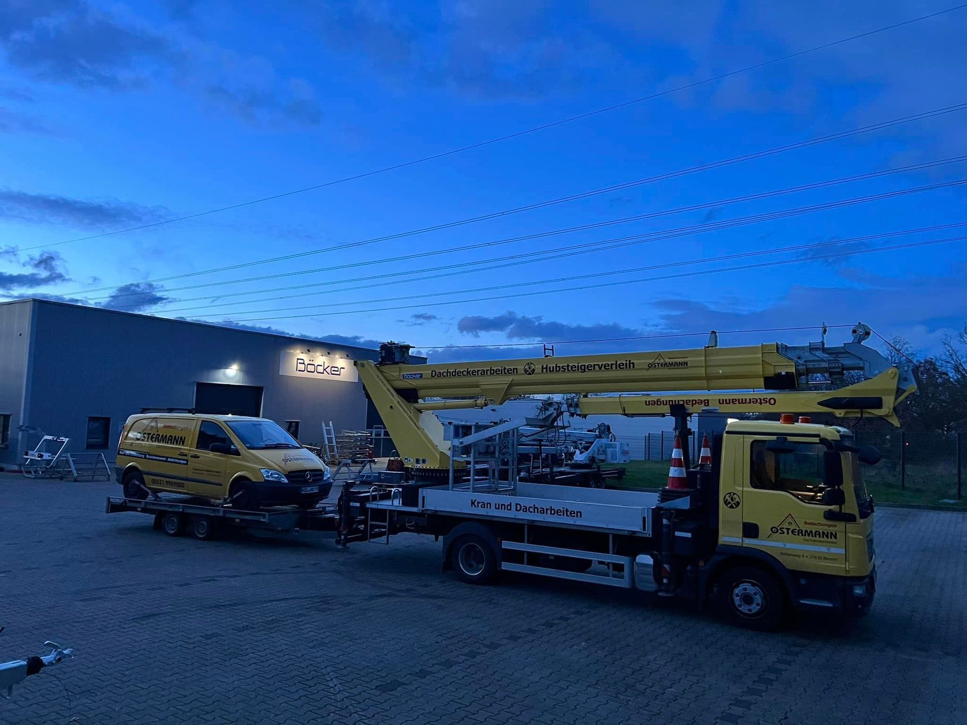 Ein gelber Lastwagen mit einem Kran auf der Ladefläche schleppt einen gelben Lieferwagen.