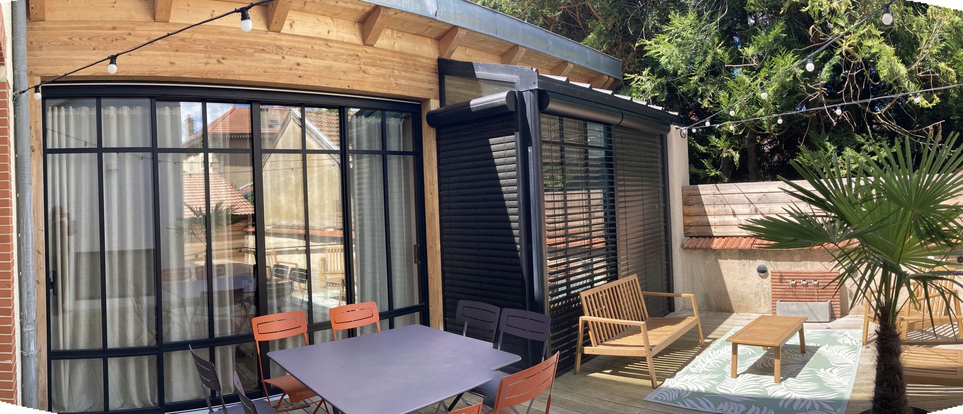 Une terrasse avec une table et quatre chaises.