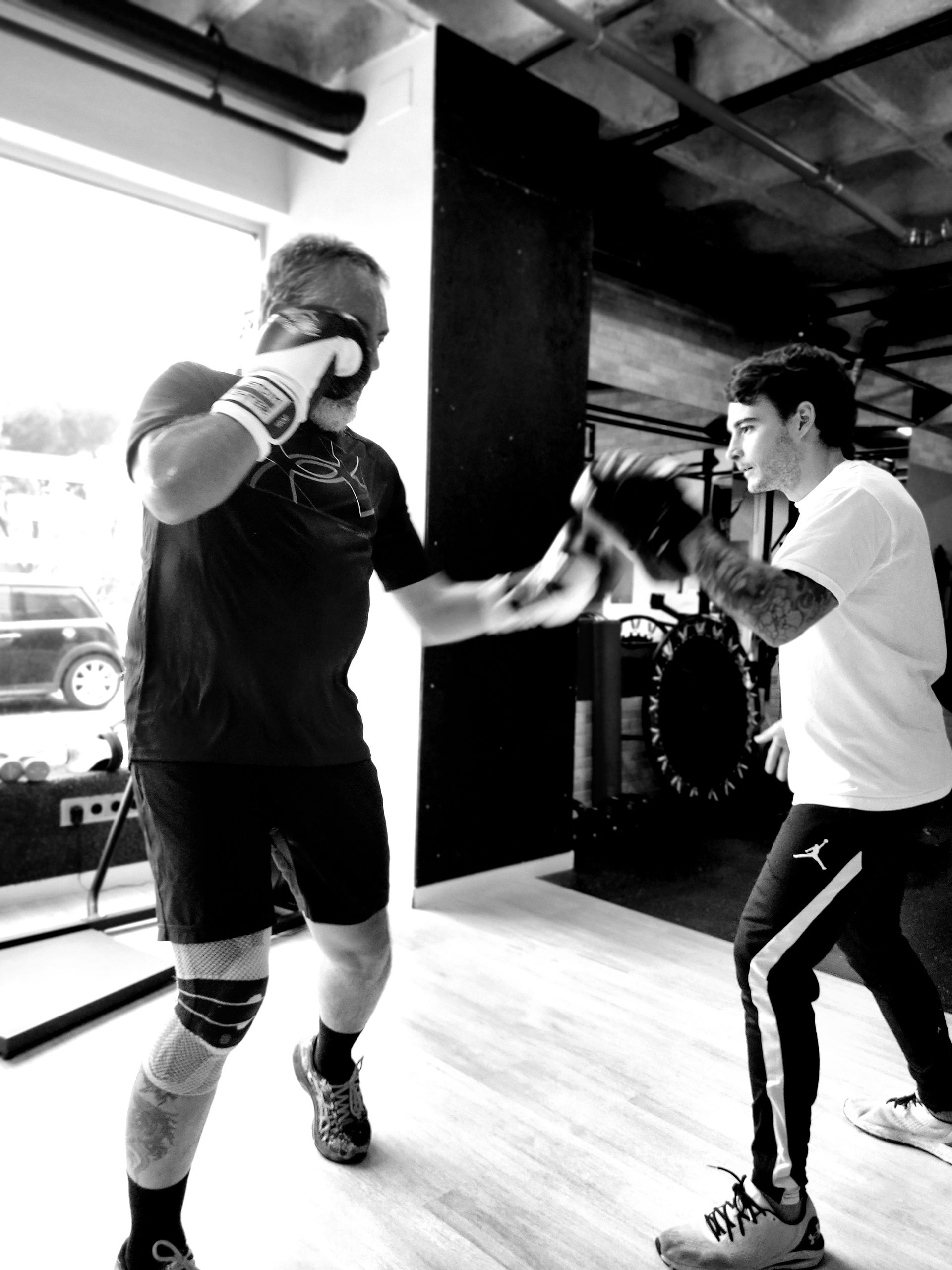 Una fotografía en blanco y negro de dos hombres boxeando en un gimnasio.