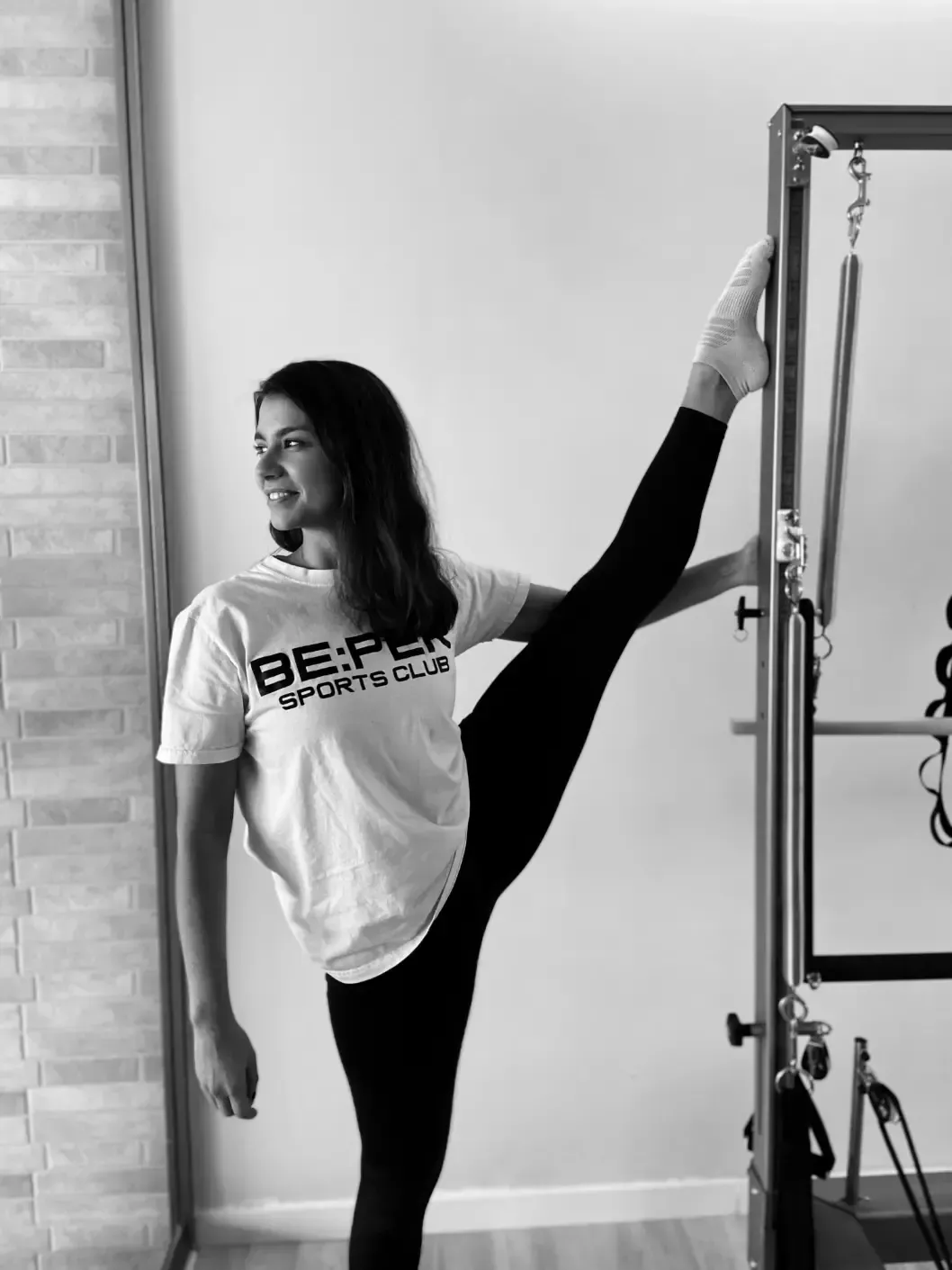 Una mujer está haciendo una división en una máquina de pilates.