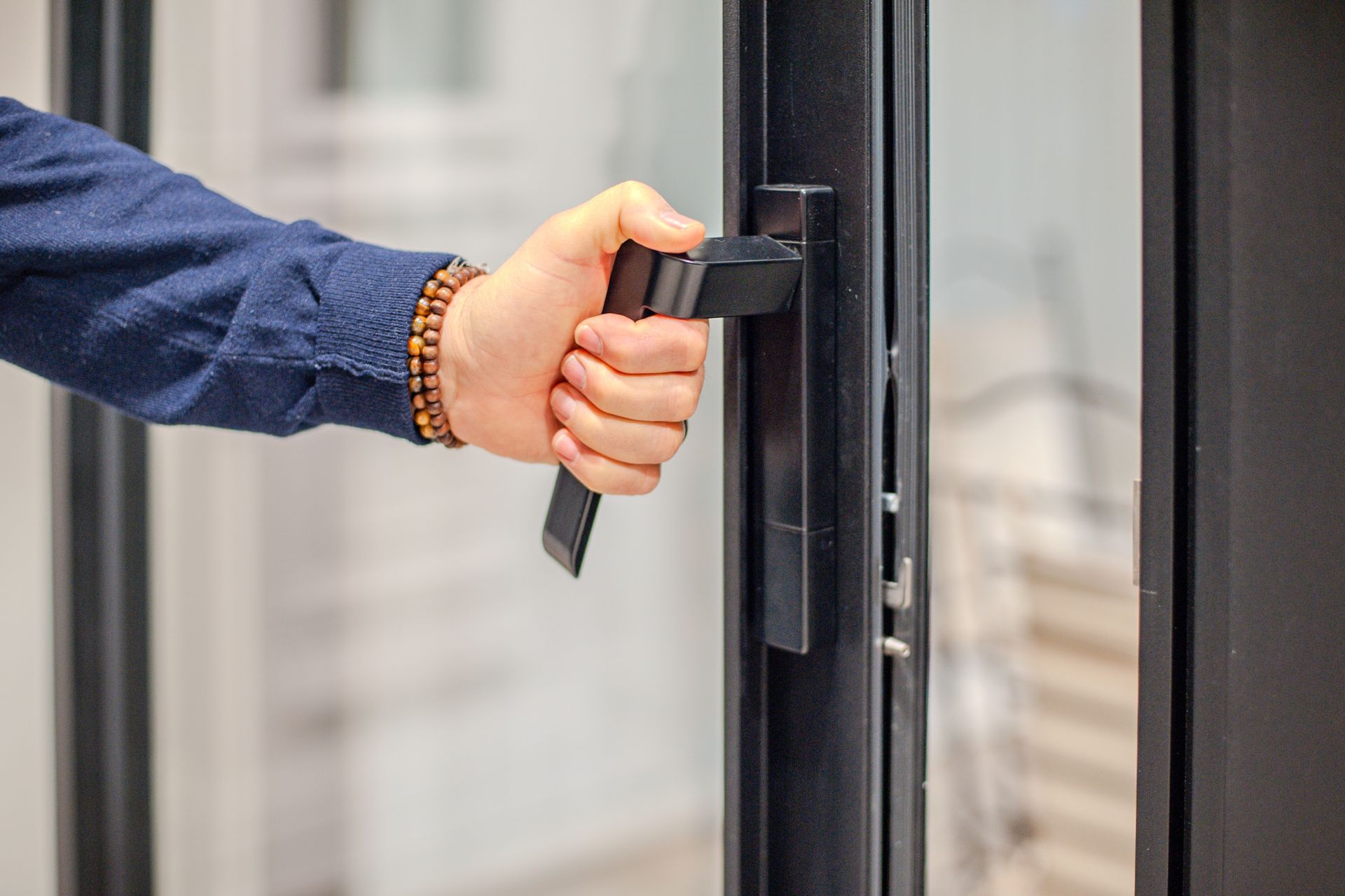 Homme qui ouvre une porte fenêtre en aluminium.