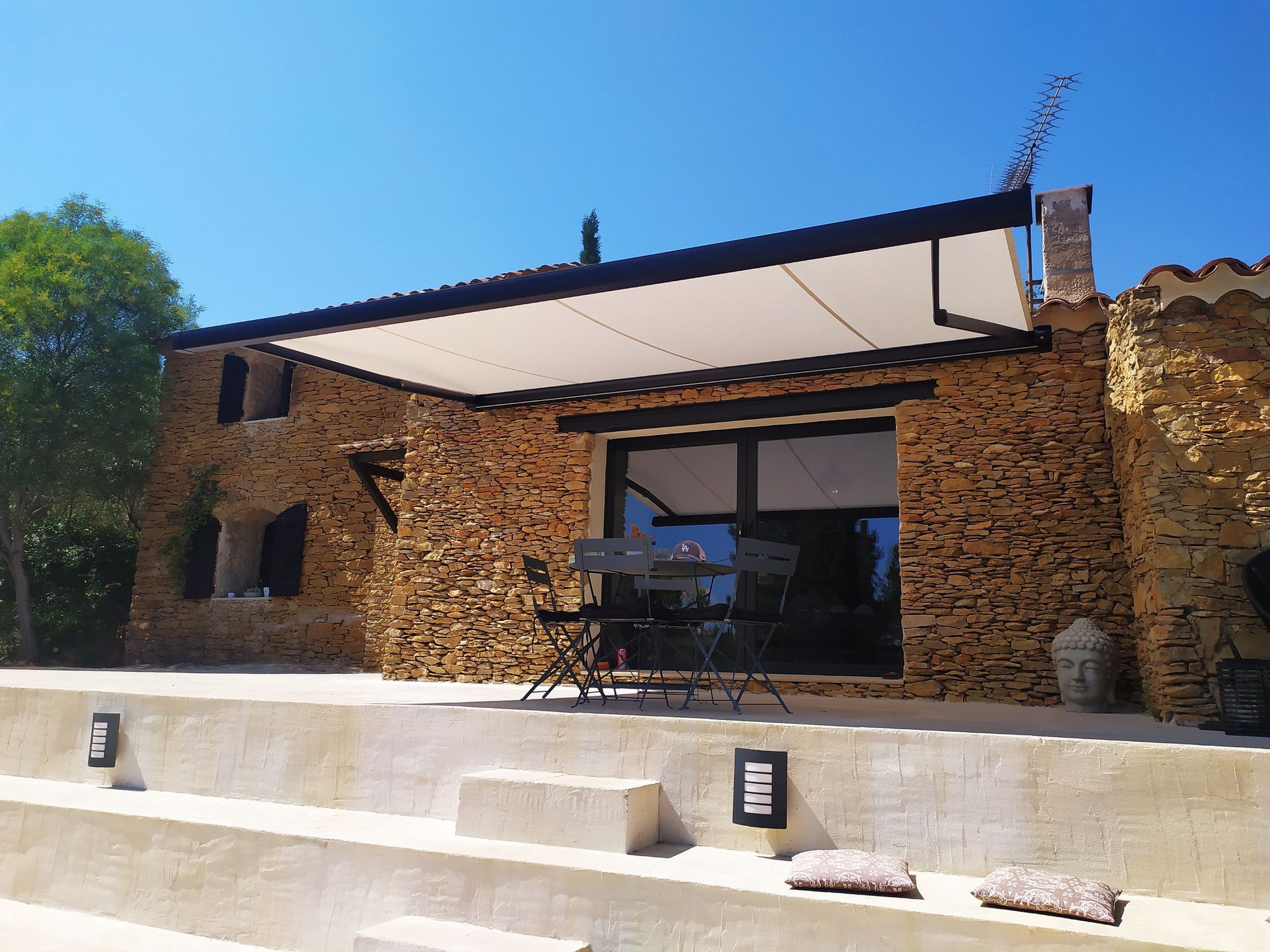 Store banne sur une maison en pierre.