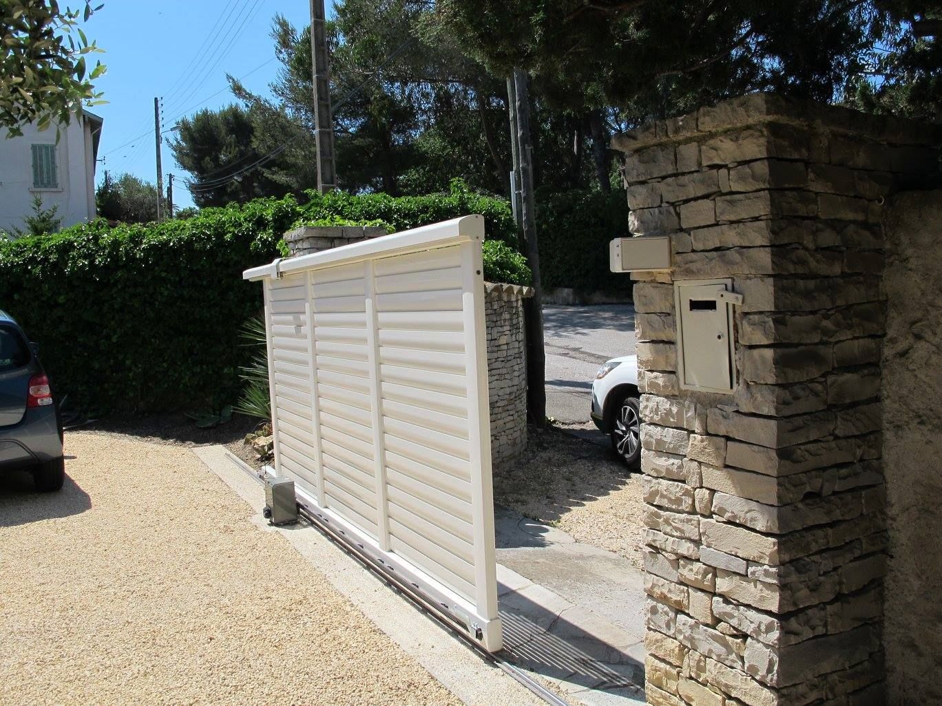 Portail coulissant blanc avec motorisation.