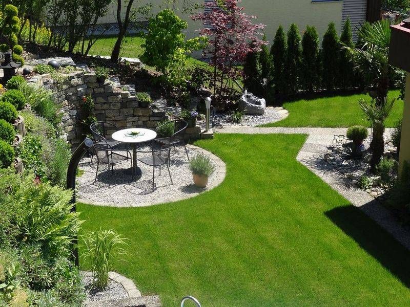 Ein Garten mit einem Tisch und Stühlen in der Mitte. Foto von der Schöni Blumen und Gartenbau GmbH