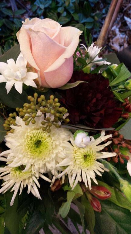 Eine Nahaufnahme eines Blumenstrausses mit einer rosa Rose und weissen Blumen. Foto von der Schöni Blumen und Gartenbau GmbH