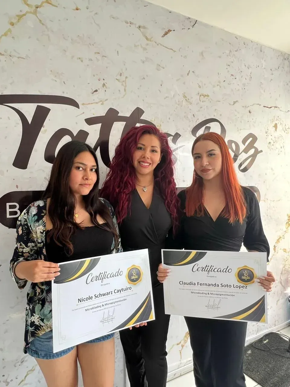 Tres personas están de pie una al lado de la otra en un estudio