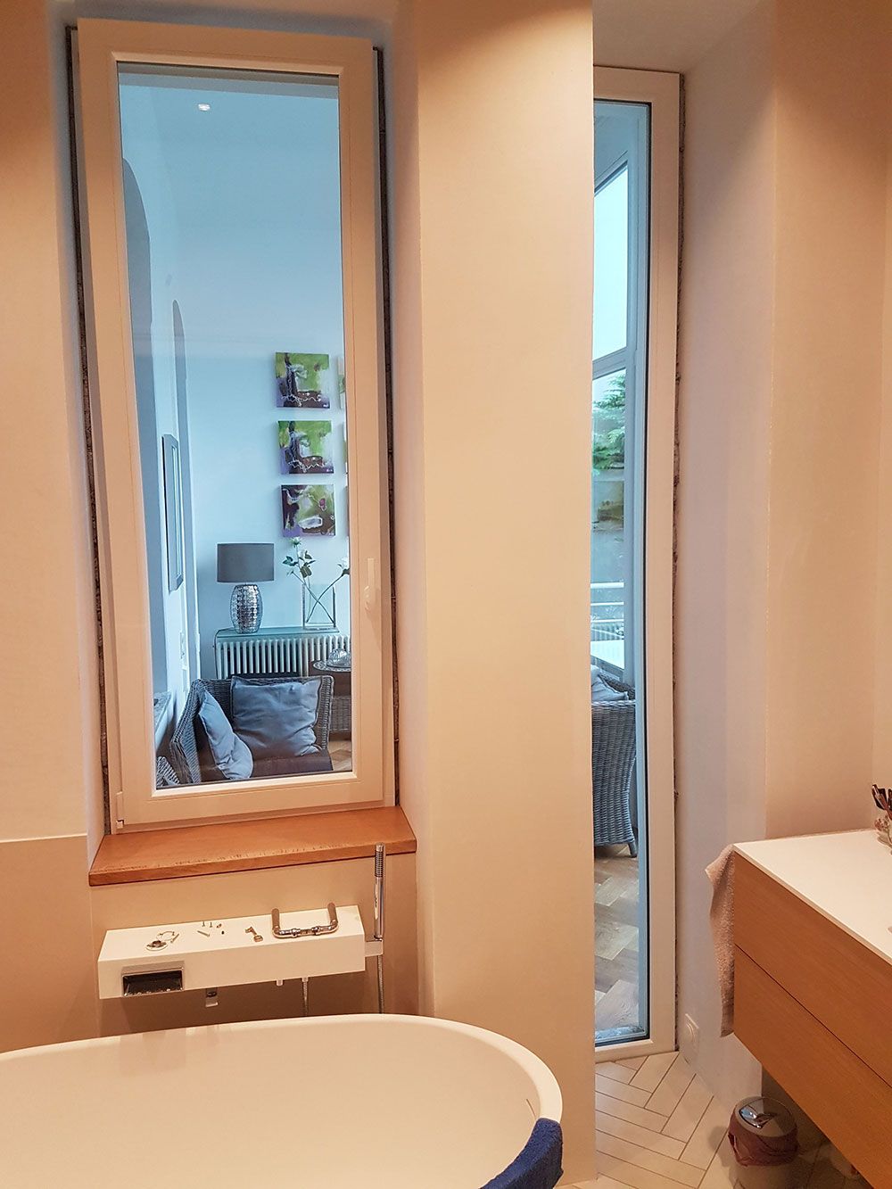 Ein Badezimmer mit Badewanne, Waschbecken, Spiegel und Fenster.