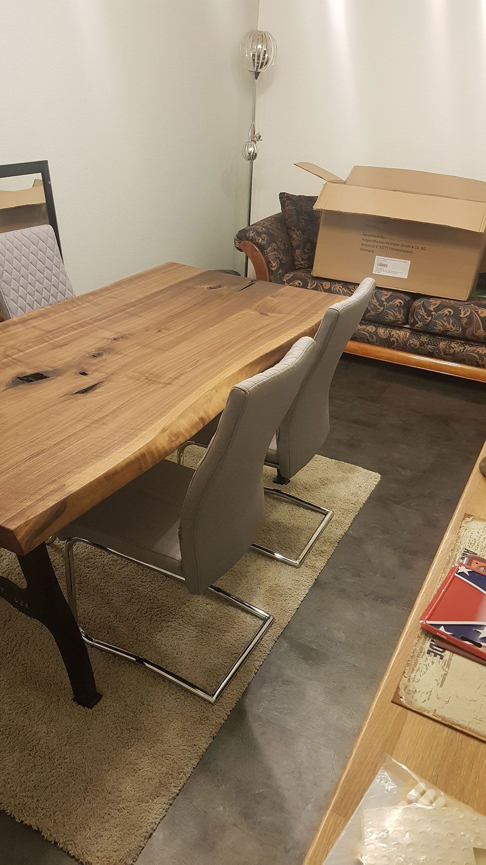 Ein Holztisch und Stühle in einem Wohnzimmer neben einem Sofa.