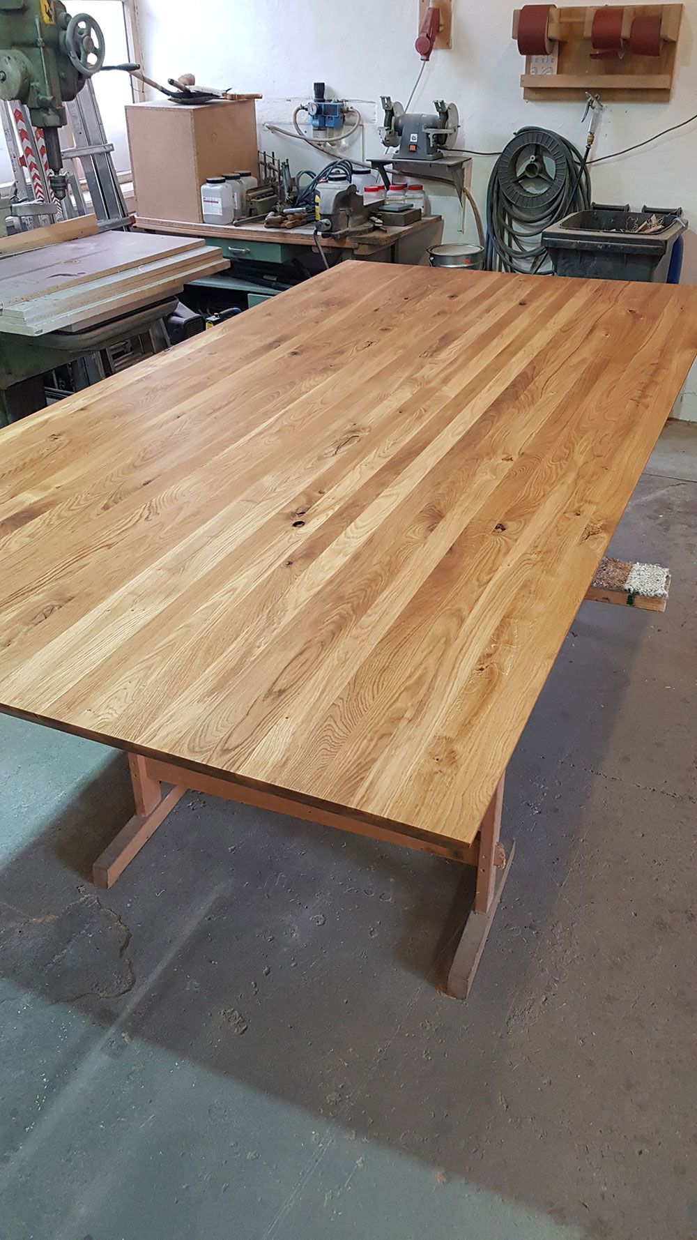 In einer Werkstatt steht ein großer Holztisch.