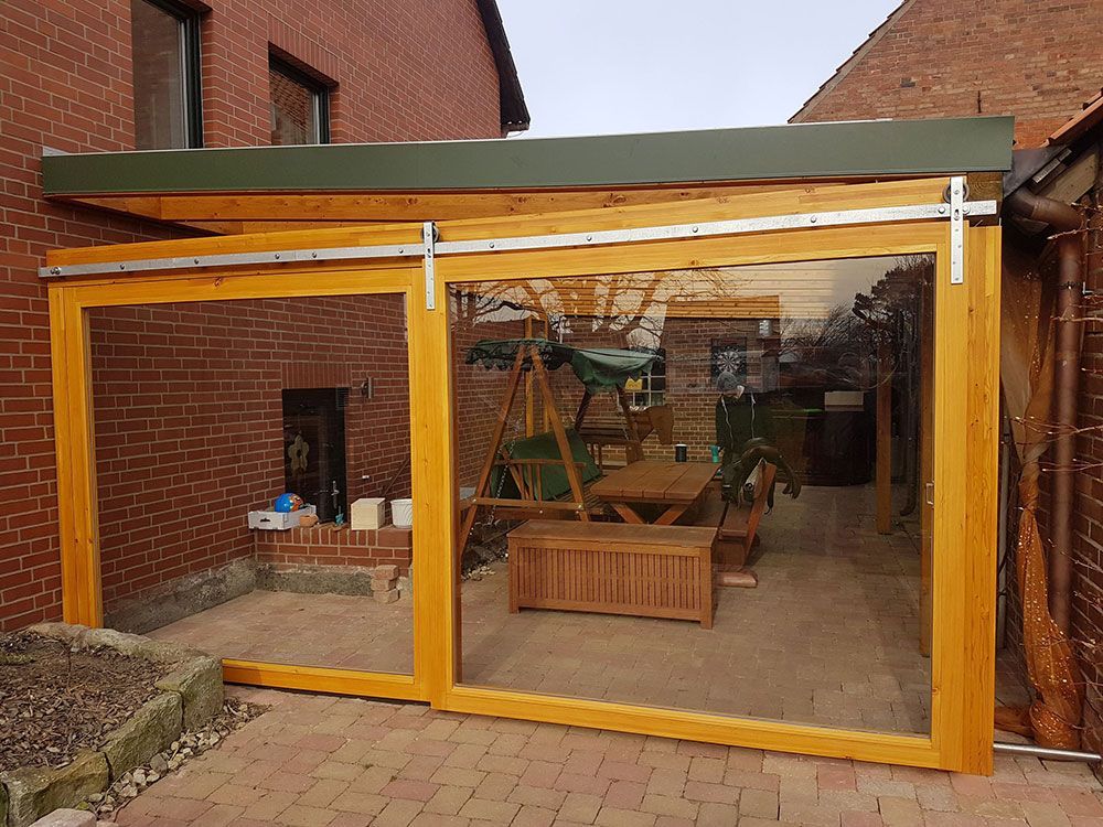 Eine Terrasse mit Tisch und Stühlen und einer Glasschiebetür.