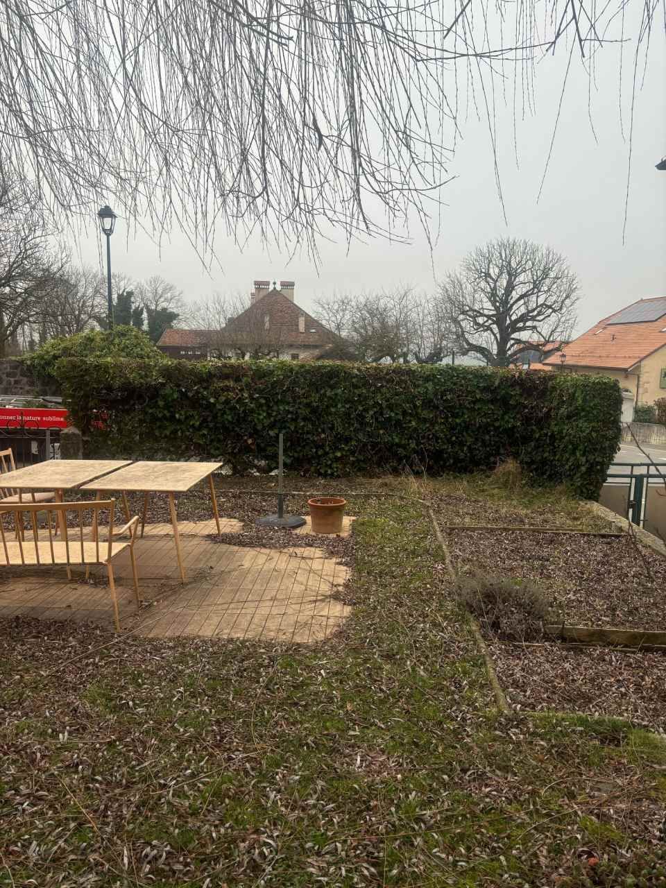 Une cour arrière avec une table et des chaises au milieu.