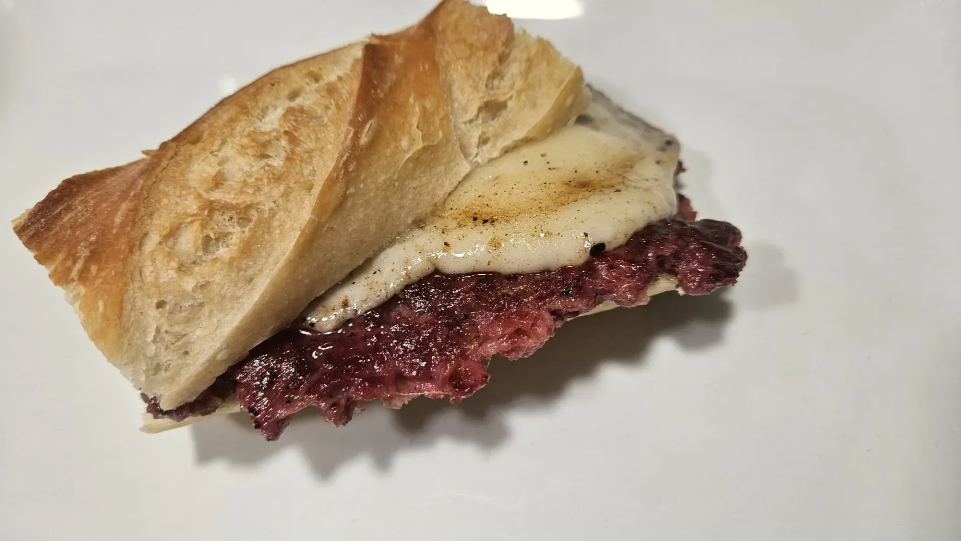 Un primer plano de un sándwich en un plato blanco.