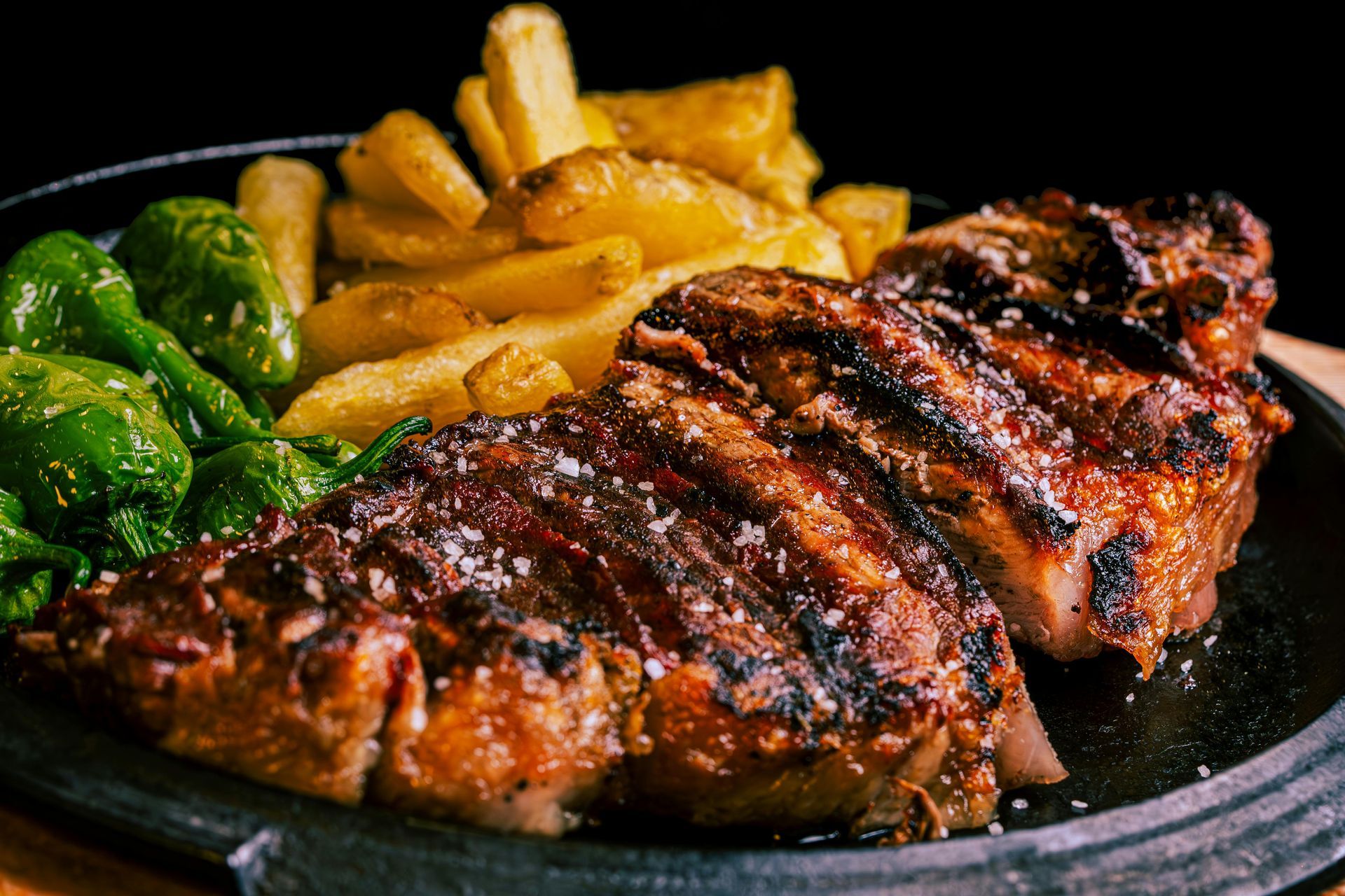 Un primer plano de un filete y patatas fritas en un plato.