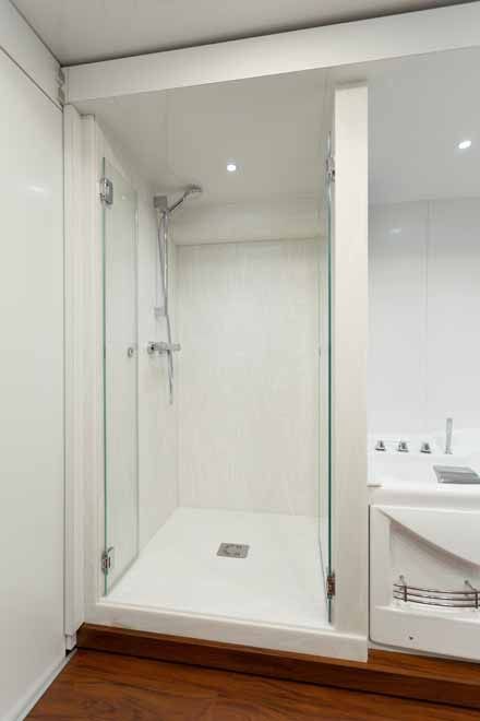 Douche en Corian, à l'italienne avec une porte ouverte