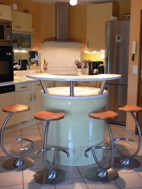 Bar en ilot central avec des tabourets stylisés