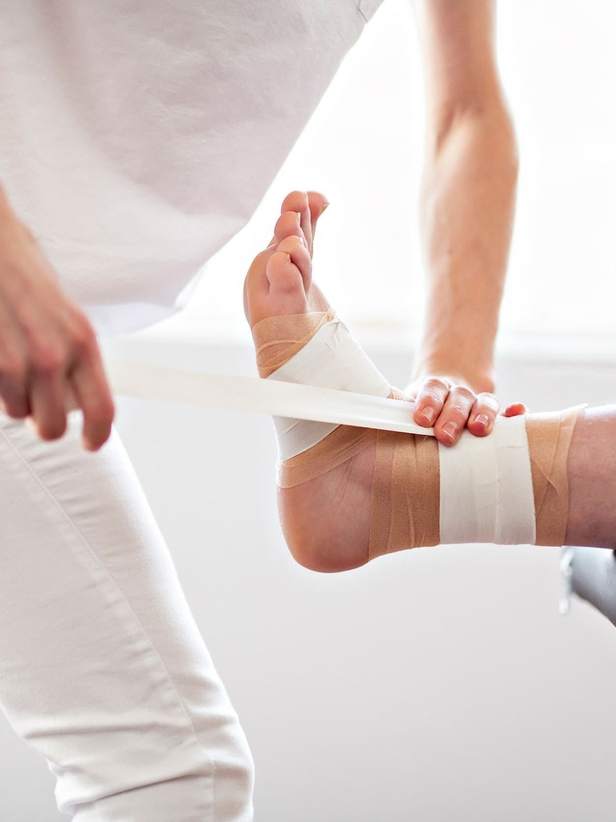Una persona se envuelve el pie con una venda.