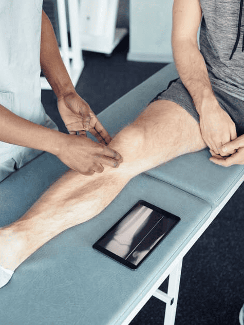Un hombre se está haciendo examinar la rodilla por un médico.