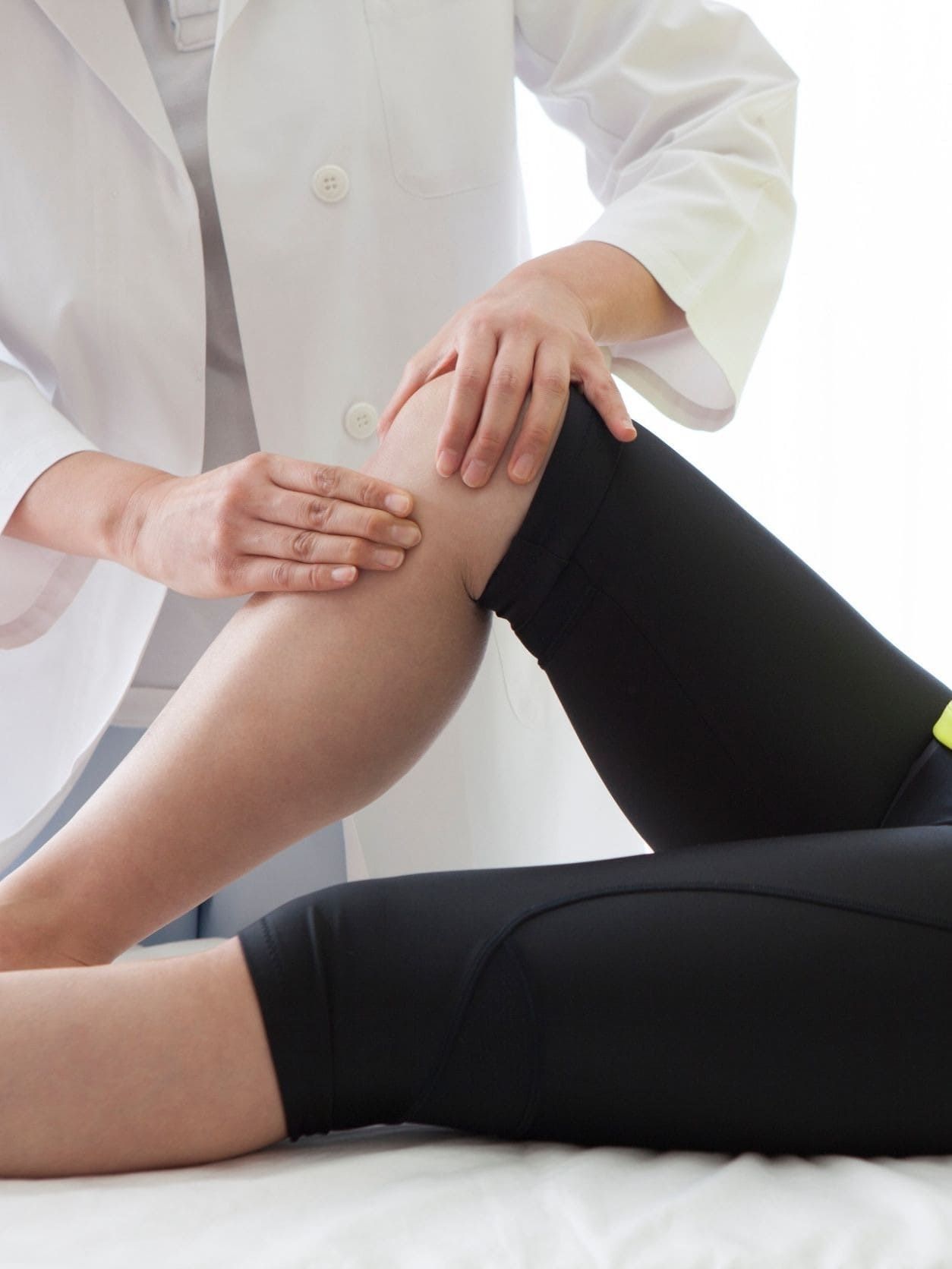 Una mujer se está haciendo examinar la rodilla por un médico.