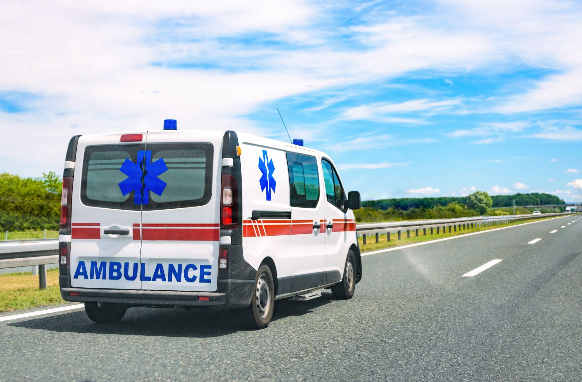 Une ambulance vue de derrière qui roule sur la route