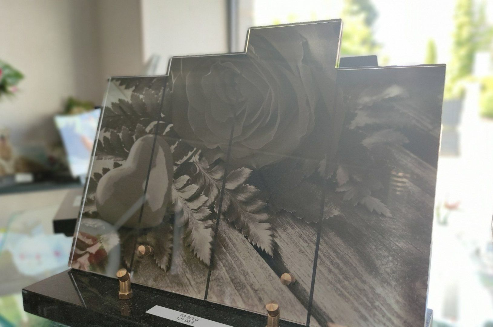 Une plaque funéraire avec une rose et un cœur gravés