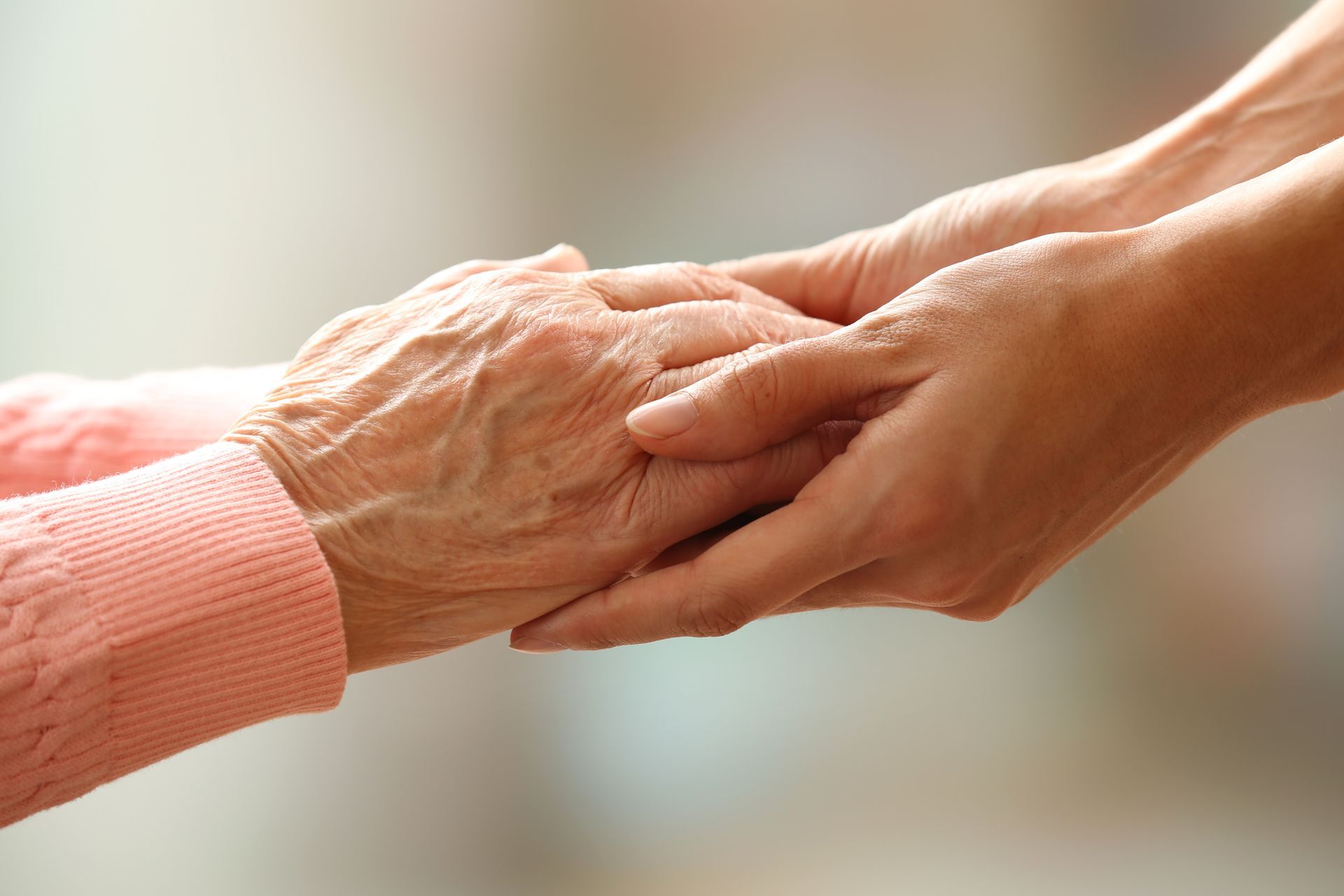 Les mains d'une jeune femme soutiennent celles d'une vieille femme