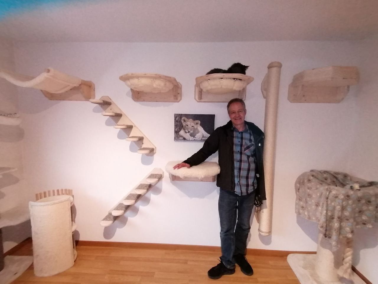 Ein Mann steht vor einem Katzenbaum