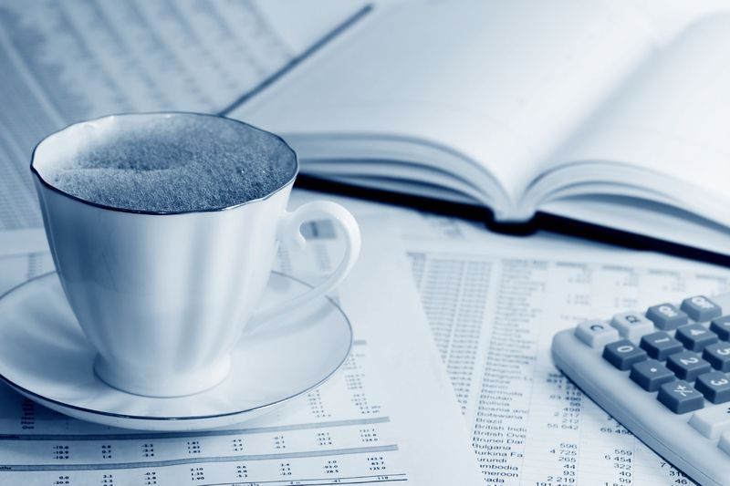 Paperit, kahvikuppi ja laskin